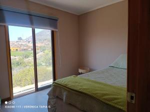 a bedroom with a bed and a large window at Cabaña, quincho, piscina y hermosas estrellas La Serena Algarrobito in La Serena +18 photos