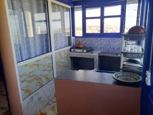 a small kitchen with a counter and a window at Dar mahfoud in Rabat