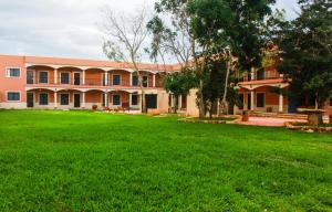 un bâtiment avec une grande cour devant lui dans l'établissement Hotel Los Frailes, Valladolid, Yucatán, à Valladolid