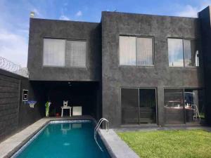 a house with a swimming pool in front of it at Casa de descanso en Yautepec in Atlihuayan