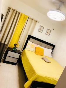 a bedroom with a bed with yellow sheets and a window at Hermoso residencial con piscina licey al medio in Licey al Medio