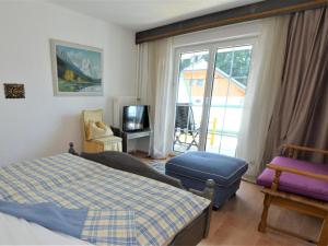 a bedroom with a bed and a chair and a window at Landhaus Leitzinger EG2 in St. Wolfgang