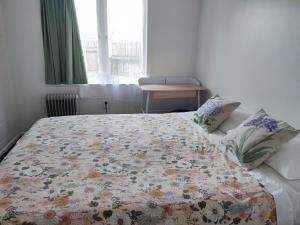 a bedroom with a bed with a floral quilt on it at Nesting In Hamilton East in Hamilton