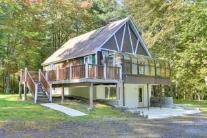 uma casa grande com um telhado de gambrel e uma escada em Glen Spey Cabin with Deck 1 Mi to Mohican Lake! em Glen Spey