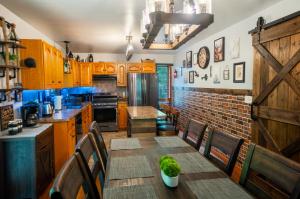 a kitchen with wooden cabinets and a table and chairs at Harmony Hill Stylish 4bd Mountain Retreat, Hot Tub, Games in Bushkill