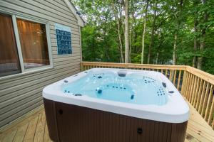 a hot tub on the deck of a house at Harmony Hill Stylish 4bd Mountain Retreat, Hot Tub, Games in Bushkill