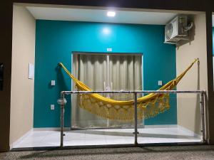 a hammock in a room with a blue wall at Dunas Flat in Galinhos