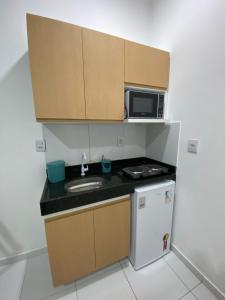a small kitchen with a sink and a microwave at Dunas Flat in Galinhos