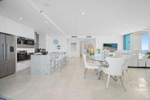 a white kitchen and living room with a table and chairs at Reflections Tower Two in Gold Coast