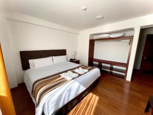 Un dormitorio con una cama con flores blancas. en Hotel Andes de Urubamba, en Urubamba