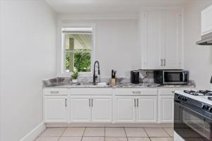 a white kitchen with a sink and a microwave at Unit 4: Large fully furnished 1 bedroom in Billings