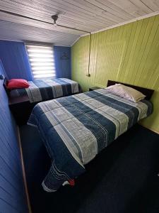 a bedroom with two beds in a room with a window at Hospedaje Sra Jenny in Puerto Montt