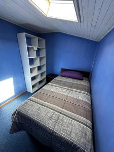 a bedroom with a bed and a blue wall at Hospedaje Sra Jenny in Puerto Montt