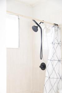 uma cortina de chuveiro com uma cabeça de chuveiro na casa de banho em La Maison 29 em Roseau