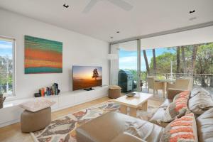 a living room with a couch and a tv at Unit 105 Plantation Resort Rainbow Beach in Rainbow Beach