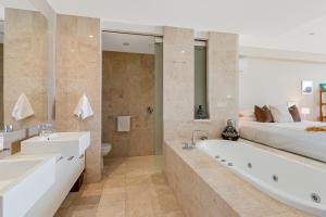 a bathroom with a large tub and a bed at 238 Santai - 2nd Floor King Studio Apartment by uHoliday in Casuarina