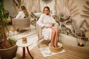Eine Frau, die auf einem Stuhl im Bad sitzt. in der Unterkunft Villa do Vale Boutique Hotel in Blumenau