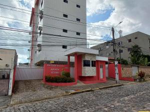 a small red building on the side of a street at Apartamento aconchegante e bastante espaçoso in Natal