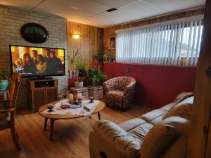 salon z kanapą i telewizorem w obiekcie Charming - 2 bedrooms basemnt, 1 full bath & rec room w mieście Kamloops
