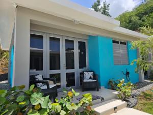 ein kleines blau-weißes Haus mit einer Terrasse in der Unterkunft Casa Arrecife 28 in Cabo Rojo