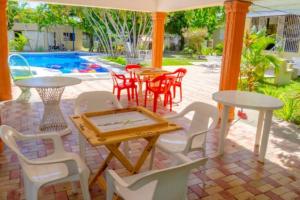 a patio with tables and chairs and a pool at Villa Eliana in Baní