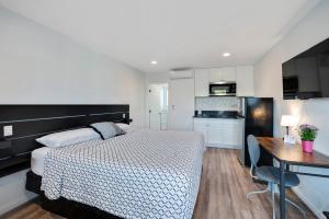 Il comprend une chambre avec un lit, un bureau et une cuisine. dans l'établissement Unik Motel, à Harbor City