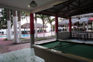 a pool table in front of a swimming pool with a pool at Villa Eliana in Baní