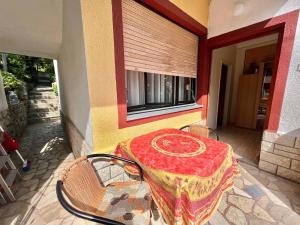 a table sitting on a porch with a red table cloth at Studio in Dramalj 45735 in Dramalj