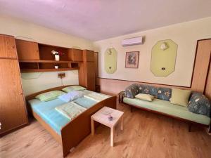 a small bedroom with a bed and a couch at Studio in Dramalj 45735 in Dramalj