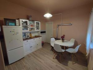 a kitchen with a table and a white refrigerator at Holiday home in Siofok - Balaton 45810 in Siófok