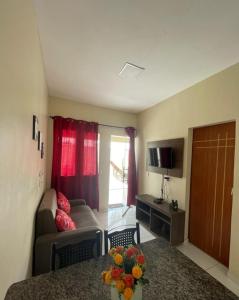 una pequeña sala de estar con sofá y TV en DUNAS RESIDENCE CASA 02, en Santo Amaro