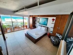 une grande chambre avec un lit et un balcon dans l'établissement Beachfront apartments Cancun, à Cancún