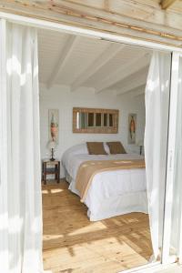 a bedroom with a large bed with white sheets at Laguna Garzón Lodge in José Ignacio