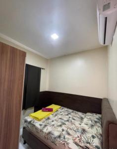 a small bedroom with a bed with a yellow book on it at DUNAS RESIDENCE CASA 02 in Santo Amaro