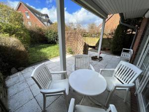 una mesa blanca y sillas en un patio en Seehund en Schönberger Strand