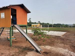 un parque infantil con un tobogán frente a una casa en GIGANTE DA BELA VISTA KM 31 ESTRADA SANTA MARIA 2KM DE RAMAL, en Iranduba