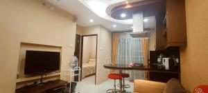 a living room with a television and a room with a bed at Classy! 2BR Medit2 West Jakarta in Jakarta
