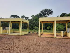 deux pavillons jaunes dans un champ planté d'arbres en arrière-plan dans l'établissement GIGANTE DA BELA VISTA KM 31 ESTRADA SANTA MARIA 2KM DE RAMAL, à Iranduba
