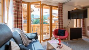 a living room with a view of a balcony at Panoramapark Soleil F Silbermond in Wengen