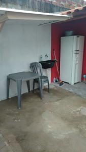a gray table and a chair in a garage at Kitnet Indaiá in Bertioga