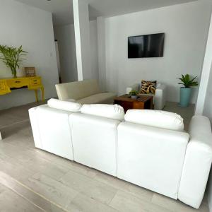 un sofá blanco en la sala de estar con TV en Casa de playa en Punta Hermosa, en Punta Hermosa