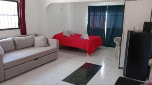 ein Wohnzimmer mit einem Sofa und einer roten Decke in der Unterkunft Casa de Luna in Playa del Carmen