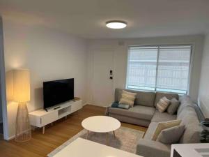 sala de estar con sofá y TV en Quiet & Private with city access and free wifi en Melbourne