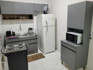La cuisine est équipée d'un réfrigérateur blanc et d'un four micro-ondes. dans l'établissement TOP RESIDENCIAL, à Sinop