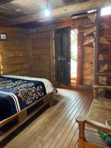 1 dormitorio con 1 cama en una cabaña de madera en Cabañas Rusticas De Zirahuen, en Zirahuén