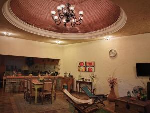 Quinta Villamarim في Chiconcuac: غرفة معيشة فيها ثريا وطاولة وكراسي