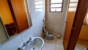 a bathroom with a sink and a toilet at Grande Hotel in Duque de Caxias