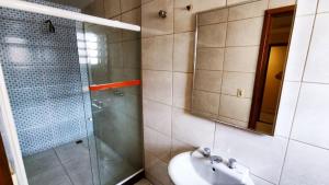 a bathroom with a sink and a shower with a mirror at Grande Hotel in Duque de Caxias