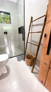 a bathroom with a toilet and a wooden ladder at Recanto Tereza Dias in Lagoinha