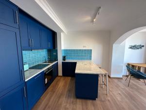 a kitchen with blue cabinets and a wooden floor at Estrela Villas in Estrela
